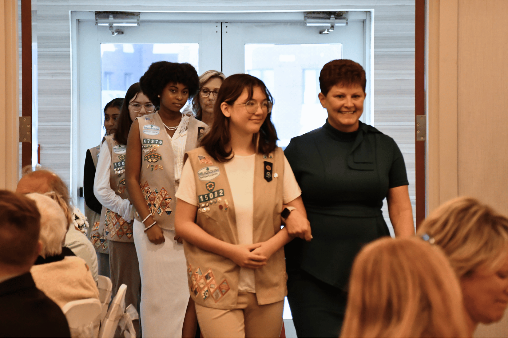 Honorees walking in with Girl Scouts